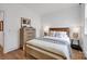 Cozy bedroom featuring a comfortable bed, hardwood floors, and a wooden dresser with decorative accents at 221 Davidson Gateway Dr, Davidson, NC 28036