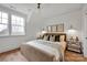 Bright bedroom featuring a plush bed, hardwood floors, and ample natural light from large windows at 221 Davidson Gateway Dr, Davidson, NC 28036