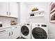 Well-equipped laundry room with modern washer and dryer, storage cabinets, and stylish decor at 221 Davidson Gateway Dr, Davidson, NC 28036