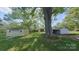 Spacious backyard with mature trees and several outbuildings at 224 Mcclain St, York, SC 29745