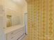 Bathroom featuring yellow floral wallpaper, a vanity with drawers, and ample cabinet space at 224 Mcclain St, York, SC 29745