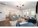 Open-concept living area with a gray sofa, blue chairs, and access to the kitchen and outdoor spaces at 2332 Paddlers Cove Dr, Lake Wylie, SC 29710