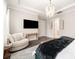 Bright main bedroom featuring a decorative chandelier, large television, and stylish sitting area at 2332 Paddlers Cove Dr, Lake Wylie, SC 29710