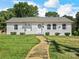 Charming single-story home featuring a well-manicured lawn and a welcoming walkway to the front door at 2633 N Sharon Amity Rd, Charlotte, NC 28205
