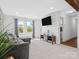 Bright and airy living room with tile flooring, a gray sectional, and a mounted flat screen television at 2633 N Sharon Amity Rd, Charlotte, NC 28205