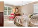 Bright bedroom with a window, quilt bed, wood dresser, and a comfortable armchair and neutral walls at 2792 Lakeshore Rd, Denver, NC 28037