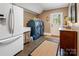 Functional laundry room with blue washer and dryer, sink, refrigerator, tile floors, and ample storage space at 2792 Lakeshore Rd, Denver, NC 28037
