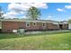 View of the back of the brick house with large backyard, a swing, and mature trees at 3017 Lynwood Dr, Lancaster, SC 29720