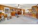 Open floor plan with knotty pine walls, carpet, rocking chairs, and kitchen access at 3017 Lynwood Dr, Lancaster, SC 29720