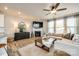 Comfortable living room with fireplace, large windows, modern ceiling fan, and hardwood flooring at 3021 Patchwork Ct, Fort Mill, SC 29708