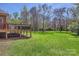 Expansive backyard with lush green grass, mature trees, and a deck, perfect for outdoor activities at 310 Frontier Cir, Indian Trail, NC 28079
