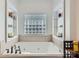 Relaxing bathroom featuring a large soaking tub with tiled surround and built in shelving at 310 Frontier Cir, Indian Trail, NC 28079