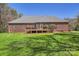 Expansive backyard with a well-maintained lawn and beautiful brick home with a spacious deck at 310 Frontier Cir, Indian Trail, NC 28079