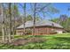 Brick house with a well-maintained lawn, mature trees, and a large deck, perfect for outdoor living at 310 Frontier Cir, Indian Trail, NC 28079