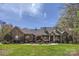 Beautiful stone and brick home with a manicured lawn, mature trees, and covered porch at 310 Frontier Cir, Indian Trail, NC 28079