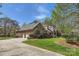 Exterior view of the home featuring brick, stone, an attached garage, and mature landscaping at 310 Frontier Cir, Indian Trail, NC 28079