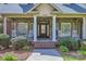 Charming front porch with stone accents, columns, and white rocking chairs at 310 Frontier Cir, Indian Trail, NC 28079