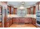 Well-lit kitchen featuring cherry wood cabinets, stainless steel appliances, and hardwood flooring at 310 Frontier Cir, Indian Trail, NC 28079