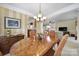 Elegant dining room featuring a wooden table with seating for six, chandelier, and views of the living room at 44455 Oriole Dr # 100, Indian Land, SC 29707