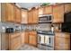 A well-equipped kitchen showcases wooden cabinetry, granite countertops, and stainless steel appliances at 44455 Oriole Dr # 100, Indian Land, SC 29707