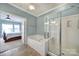 Tranquil bathroom features a soaking tub and a glass-enclosed shower, seamlessly connected to the bedroom at 44455 Oriole Dr # 100, Indian Land, SC 29707