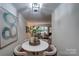 Cozy dining area with a round table, four chairs, and an open view into the living room, creating an inviting and connected living space at 4609 Hedgemore Dr # I, Charlotte, NC 28209