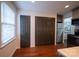 Hallway featuring dark bi-fold closet doors, window with blinds, and stainless refrigerator, leading to the kitchen and living areas at 4609 Hedgemore Dr # I, Charlotte, NC 28209