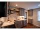 Well-lit kitchen boasts stainless appliances, grey cabinets, floating shelves, and a sleek countertop, complemented by hardwood flooring at 4609 Hedgemore Dr # I, Charlotte, NC 28209