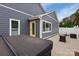Home exterior featuring a hot tub, concrete patio, gray siding, a yellow entry door and a white privacy fence at 4808 Truscott Rd, Charlotte, NC 28226