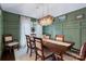 Elegant dining room featuring wainscoting, a stylish chandelier, and a dark wood table with seating at 4808 Truscott Rd, Charlotte, NC 28226