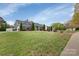 Charming home exterior with a lush green lawn, tall evergreens, and landscaped flowerbeds at 4808 Truscott Rd, Charlotte, NC 28226