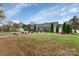 Charming home exterior with a lush green lawn, tall evergreens, and landscaped flowerbeds at 4808 Truscott Rd, Charlotte, NC 28226