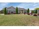 Charming home exterior with a lush green lawn, tall evergreens, and landscaped flowerbeds at 4808 Truscott Rd, Charlotte, NC 28226