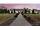 Charming single-story home featuring a well-manicured lawn and inviting yellow front door at twilight at 4808 Truscott Rd, Charlotte, NC 28226