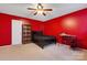 Red bedroom with a ceiling fan, bed, bookshelf, and desk for various activities at 5519 Burning Ridge Dr, Monroe, NC 28110
