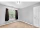 Clean bedroom with neutral tones, a window providing natural light, and a simple, cozy atmosphere at 5519 Burning Ridge Dr, Monroe, NC 28110
