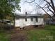 Exterior of home with metal roof, partial fence, and lush backyard at 605 W Elm St, Shelby, NC 28150