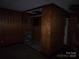 Unfinished basement room featuring stained concrete floor, wood paneling, and closet space at 605 W Elm St, Shelby, NC 28150