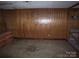 Unfinished basement room with stained concrete floor, wood paneling, and an electrical box at 605 W Elm St, Shelby, NC 28150