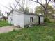 Exterior view of a shed with block walls and overgrown landscaping, awaiting restoration and creative transformation at 605 W Elm St, Shelby, NC 28150
