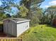 The storage shed is surrounded by grass and mature trees at 608 Forney Ave, Lincolnton, NC 28092