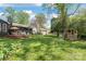 Spacious backyard with lush green grass, mature trees, and a charming playhouse for outdoor fun at 6100 Rose Valley Dr, Charlotte, NC 28210