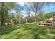 Expansive backyard with mature trees, playhouse, and outdoor seating, perfect for Gathering activities at 6100 Rose Valley Dr, Charlotte, NC 28210