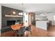 Dining room featuring dark brick fireplace, modern lighting, and an adjacent modern kitchen at 6100 Rose Valley Dr, Charlotte, NC 28210