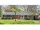 Charming house with gray brick exterior and a well-manicured lawn with beautiful flowers at 6100 Rose Valley Dr, Charlotte, NC 28210