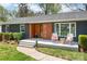 Inviting single-story home featuring a wood accent wall, front porch, and well-manicured lawn at 6100 Rose Valley Dr, Charlotte, NC 28210