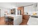 Modern kitchen featuring a large island with seating, wood cabinets, and a view into the dining room at 6100 Rose Valley Dr, Charlotte, NC 28210