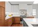Contemporary kitchen with white and wood cabinetry, stainless steel appliances, and bright countertops at 6100 Rose Valley Dr, Charlotte, NC 28210