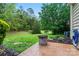 Outdoor patio with stone fire pit, green lawn, mature trees, and landscaped garden at 6312 Crosshall Pl, Waxhaw, NC 28173