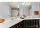 Bright bathroom featuring double sinks, vanity with dark wood cabinets and modern fixtures at 6312 Crosshall Pl, Waxhaw, NC 28173